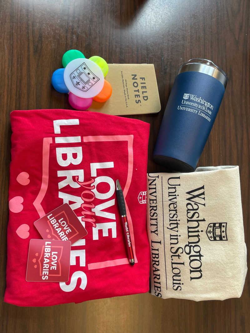 미국 워싱턴대학교 세인트루이스의 심볼이 새겨져있는 텀블러, 티셔츠, 볼펜, 가방, 노트 가 진열되어 있다.